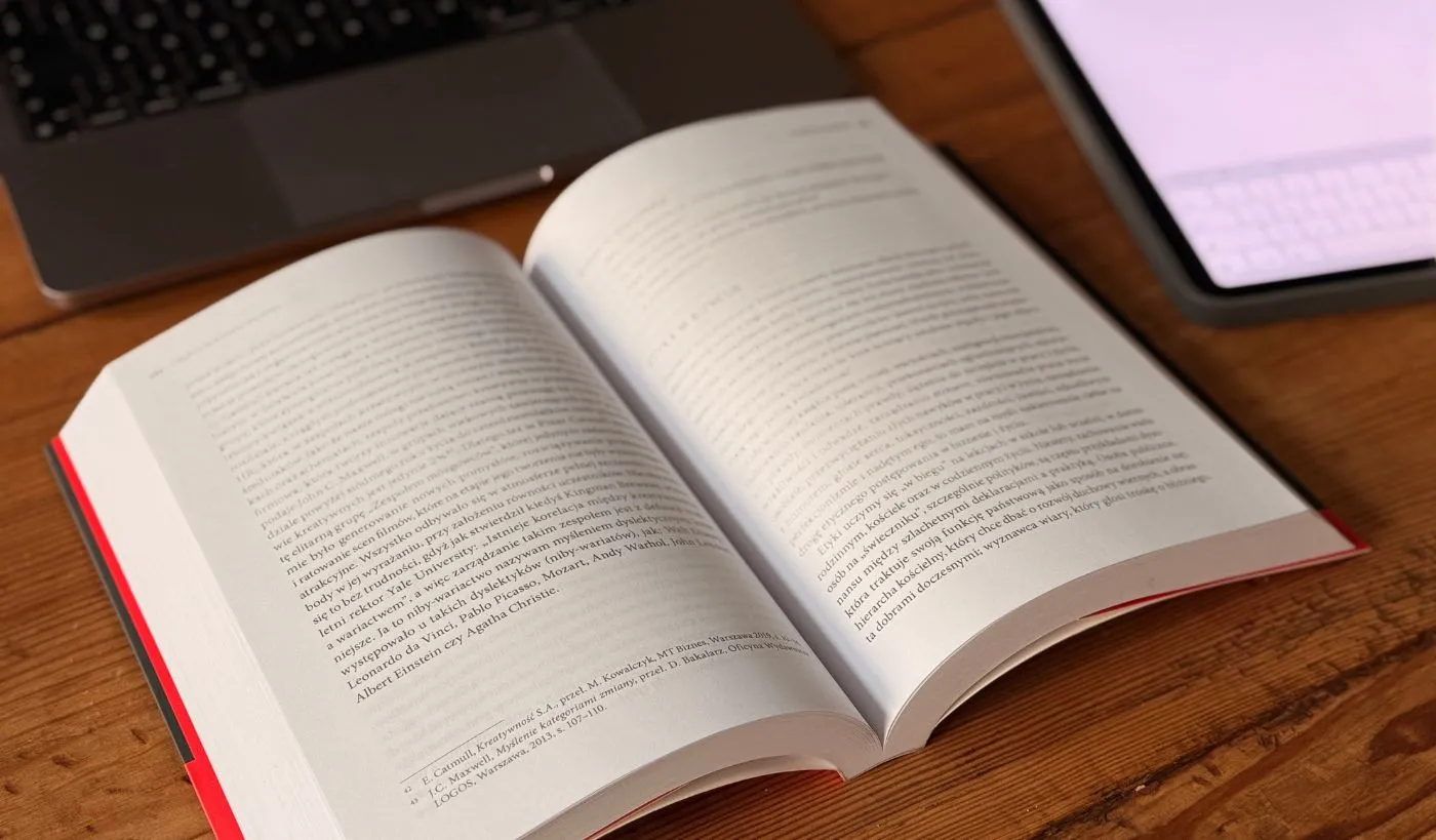 Notowanie i podsumowywanie książek biznesowych podczas czytania, notes i laptop na biurku, praca z wiedzą i rozwój kompetencji